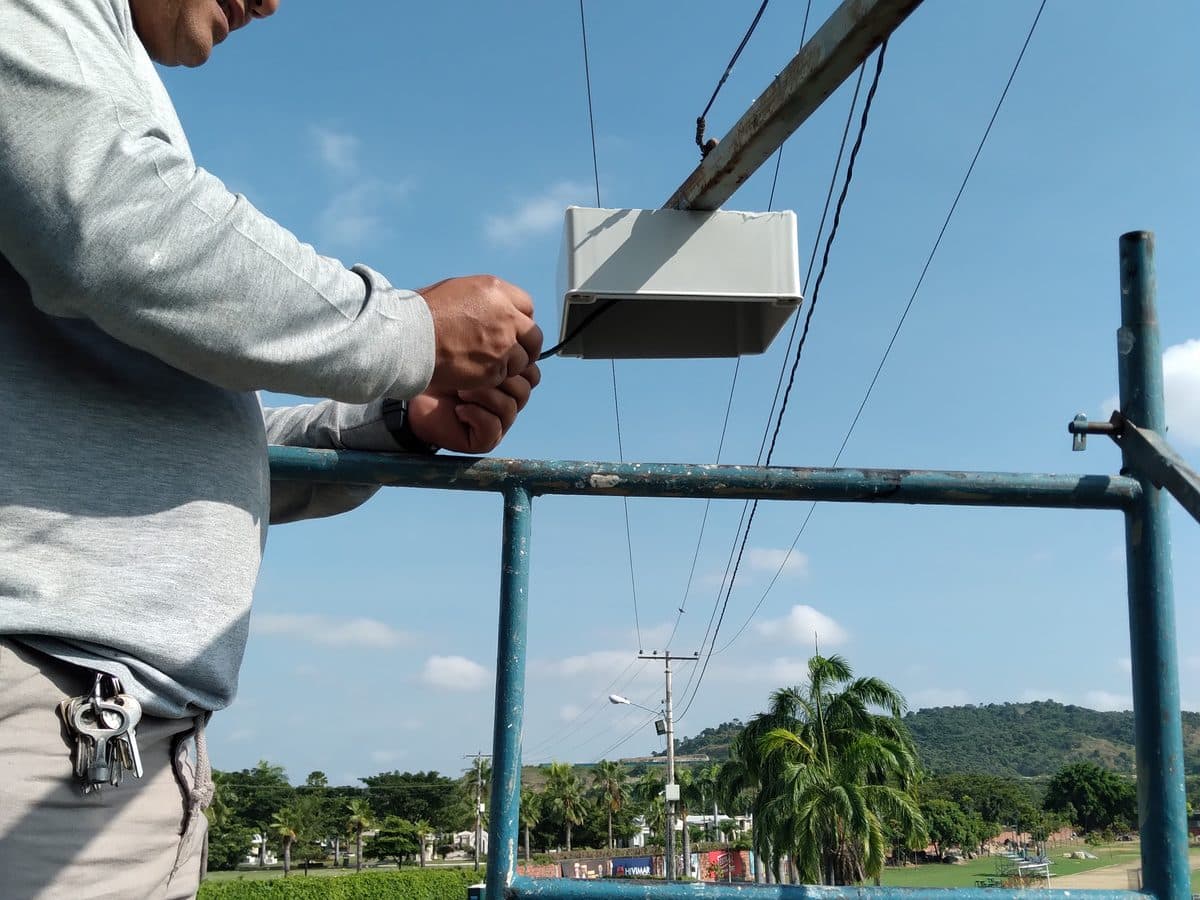Técnico instalando un gabinete de intemperie sobre estructura metálica.